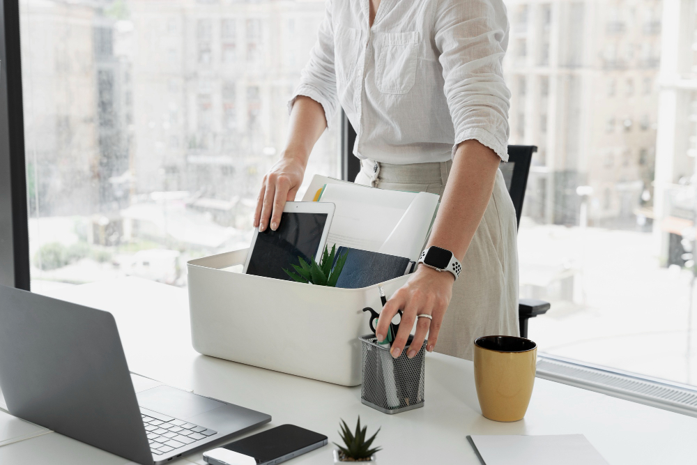 Kobieta w biurze pakująca swoje rzeczy do pudełka - staż pracy | Job Station